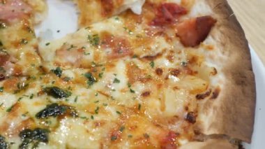 Tahta masadaki bir tabakta peynirli pizza.