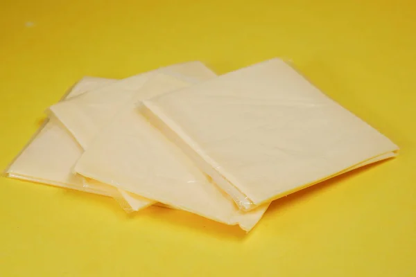 Paquete Transparente Con Rodajas Queso Sobre Amarillo — Foto de Stock