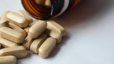 Bir şişeden dökülen çeşitli vitamin kapsüllerinin yakınında. Yüksek kalite 4k görüntü
