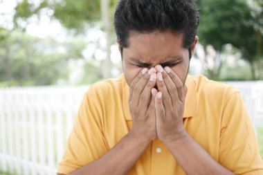 Hasta adamın grip alerjisi var. Hapşırıyor ve burnunu siliyor.