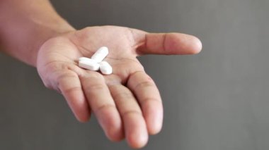 Konteynırdan dökülen haplarla adamın eli. .