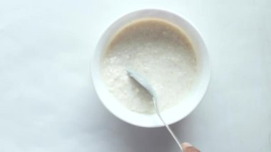 Yulaf, muz ve süt siyah arka planda bir kasede .