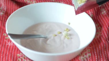  putting yogurt in granola Musli in a bowl