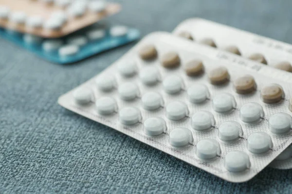 birth control pills on wooden background, close up .