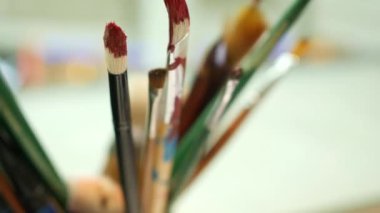 Sanat fırçasını masanın üzerindeki bardakta kapat .