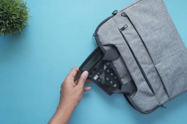 Genç adamın çantasına ofis gereçlerini koyuşunun üst görüntüsü. .