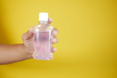  El ele tutuşan bir gargara suyu kabı. .