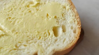  Taze tereyağı ekmeğe yayılıyor. ,