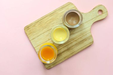  Karamel, çikolata ve mango pudingi pembe arka planda cam bir kavanozda. ,