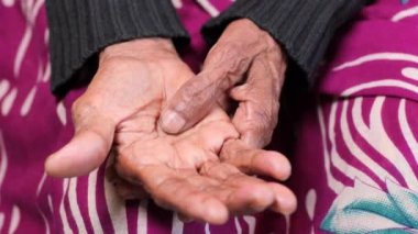 Kanepede oturan, acıdan muzdarip yaşlı kadın. .