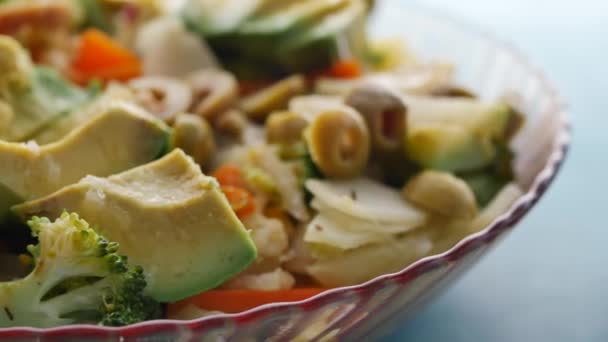 把鳄梨蔬菜沙拉放在桌上的碗里 — 图库视频影像