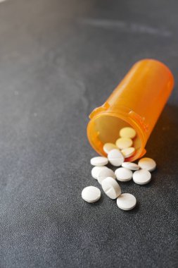  Pembe üzerine beyaz renkli tıbbi haplar dökülüyor. ,