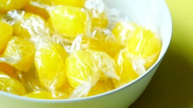 Sarı arka plandaki bir kasede limon şekerini kapat. .