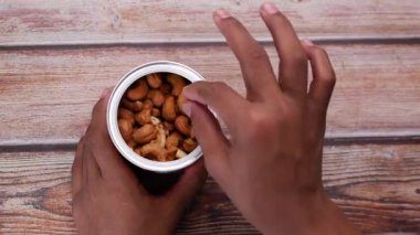 Konteynırın üst görünümünden elle kaju fıstığı topladım. ,