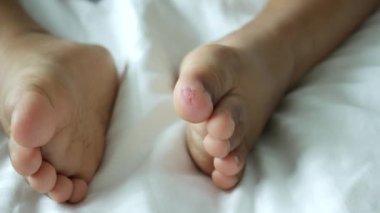 close up of 5 years old child dry feet on bed .