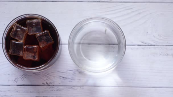 Membandingkan Minuman Ringan Dengan Segelas Air Atas Meja — Stok Video