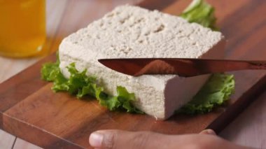  Soya peynirini bıçakla kesen ellerin üst görüntüsü ,