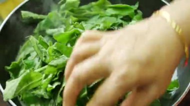 Taze ıspanak yapraklarını tencerede pişiriyorum. ,