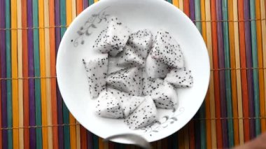 Yavaş çekimde kaşıkla ejderha meyvesi dilimi.