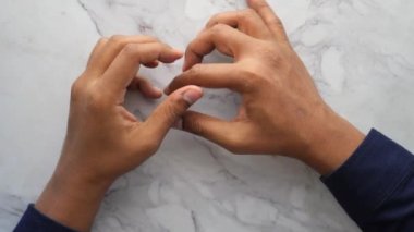 Genç adam kalp ağrısı çekiyor ve göğsünü eliyle tutuyor. .