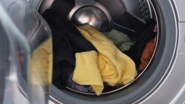 bir çamaşır makinesine havlu ve bez koymak