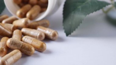 Beyaz üzerine düşen bitkisel ilaç kapsülü .