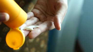 Açık havada güneş kremi kullanarak kişinin elini kapat. ,