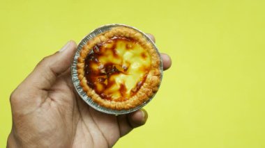  eating a egg tart with a spoon .