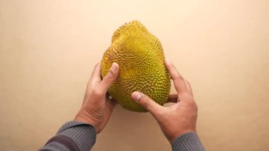  men holding a jackfruit top view ,