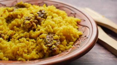 boiled yellow rice with meats on a plate .