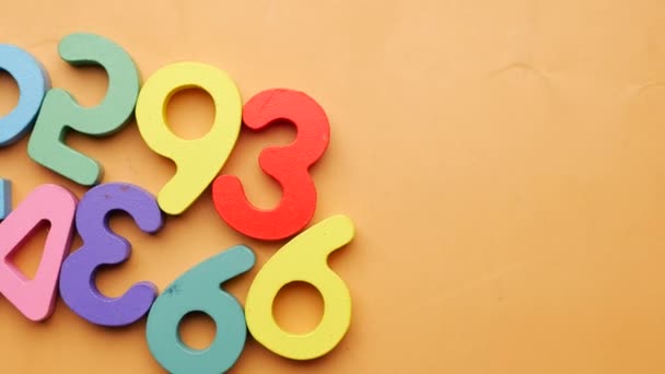 Colorful Plastic Numbers Orange Background Top View — Stockvideo