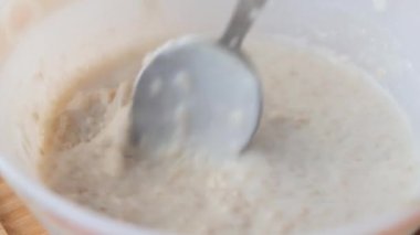  mixing oats, banana and milk in a bowl .