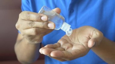 Virüsü önlemek için dezenfektan jel kullanarak genç adamın elini kapat..