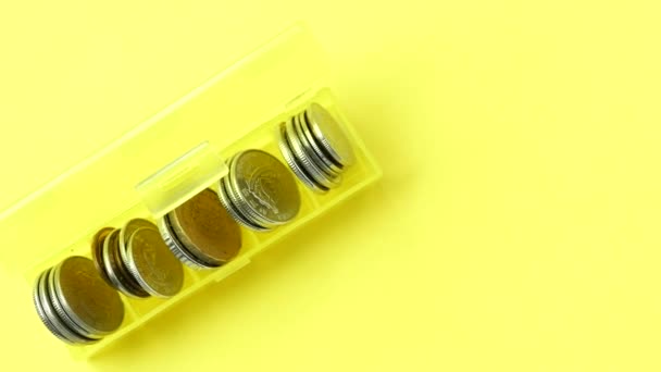Крупним Планом Монети Пластиковій Коробці Жовтому Фоні — стокове відео