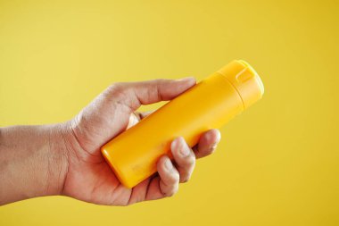  men holding a sunscreen cream container .