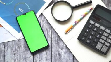 finansal grafik, hesap makinesi ve not defteri masanın üzerinde.