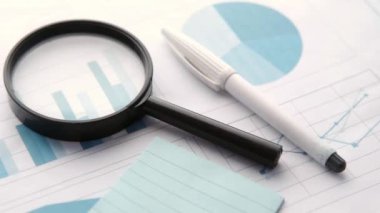 finansal veriler ve mavi üzerine büyüteç 