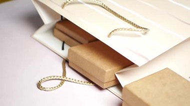 taking a gift out from a packet on table .