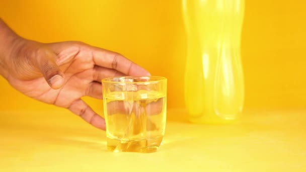 Hand Holding Glass Water Yellow Background — Αρχείο Βίντεο