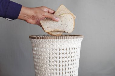 throwing old bread in a garbage bin ,