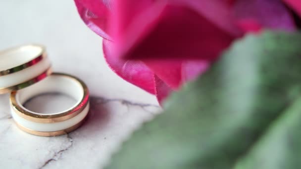 結婚指輪を閉じてテーブルの上にバラの花を咲かせ — ストック動画