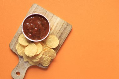 Masada bir kase cips ve salsa sosu.