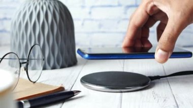 Kablosuz şarj pedi kullanarak akıllı telefon şarj ediliyor. 