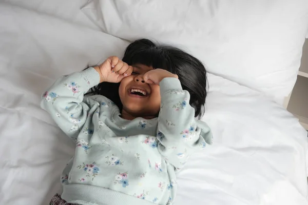 a upset child girl crying on bed .