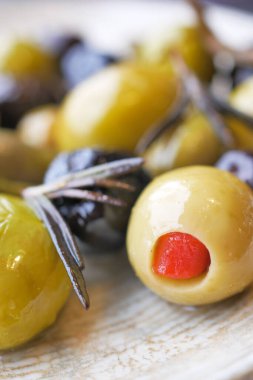 black and green olive with herbs on a plate 