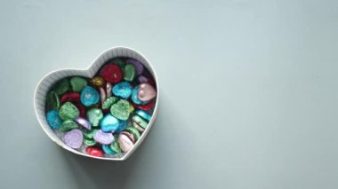  small heart shape gift with candy on r gray background .