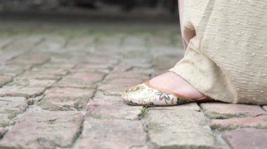 slow motion of women feet waking with a sandal on street .