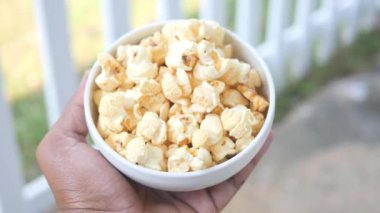  men holding a bowl of popcorn .