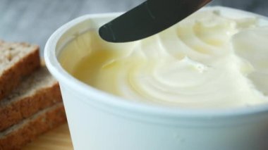 Beyaz zemin üzerinde ekmek olan bir kabın içinde taze tereyağı .