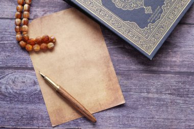 Kur 'an-ı Kerim ve tespihi masaya koyun.